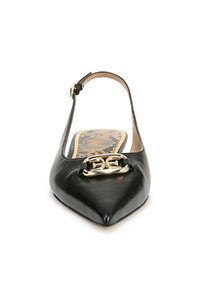 Chaussure slingback en cuir noir avec un bout pointu, présentant un détail en métal doré avec logo et une semelle texturée. Design élégant.