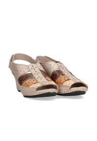 Zapatos de cuero beige con un diseño recortado, con acentos marrones y tostados, tacón cerrado, costuras decorativas y suela texturizada.