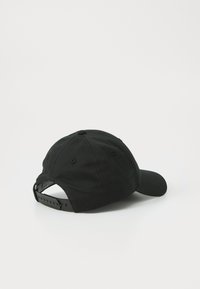 Casquette de baseball noire avec un visière courbée, sangle en plastique ajustable à l'arrière, en coton doux, sans motif ni accents visibles.