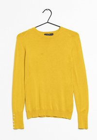 Gelber Strickpullover mit langen Ärmeln, rundem Ausschnitt und dekorativen Knöpfen an den Manschetten. Weiche Textur, minimalistisches Design.