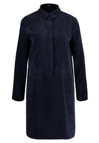 Mjärknavy kordflodress med krage, långa ärmar och rak skärning. Har en framknäppning och en strukturerad yta.