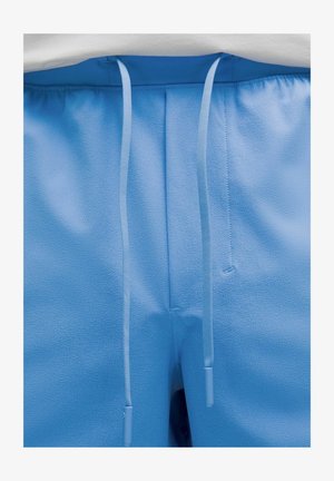 Lyseblå shorts med en tekstureret overflade, der har snor i taljen og flade forlommer. Glat stof uden synlige mønstre.