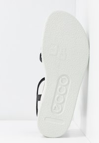Sandale noire à semelle blanche texturée, avec le nom de la marque "ECCO" et la taille "38" embossés sous la semelle. Design simple, quincaillerie minimale.