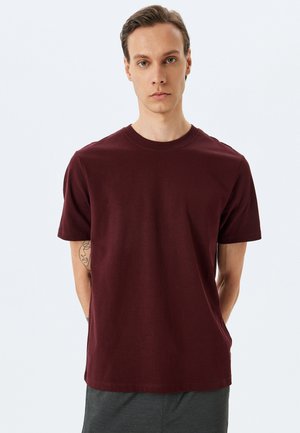 Camiseta de algodón burdeos con mangas cortas, escote redondo y una textura suave. Presenta un diseño sencillo y dobladillo recto.