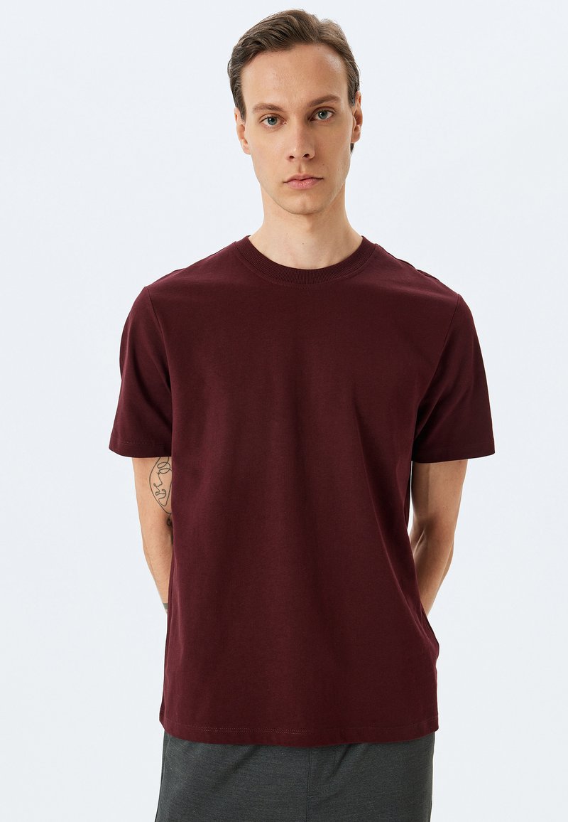Bordeaux cotton t-shirt med korte ærmer, en rund halsudskæring og en glat overflade. Har et simpelt design og lige kant.