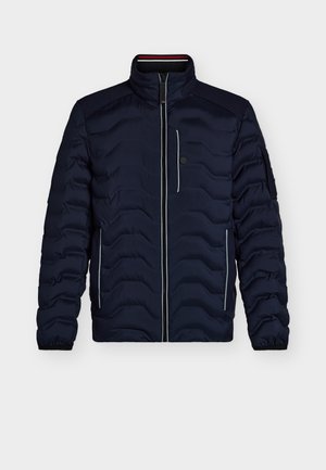Námornícka modrá prešívaná bunda s vysokým golierom, horizontálne prešívaným vzorom, zipsom vpredu, kontrastným bielym lemovaním a bočnými vreckami.