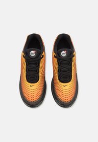 Mustat ja oranssit Nike Air Max -kengät, joissa on verkkomateriaali ylemmässä osassa, pyöreä kärki ja mustat nauhat; näkyvissä oleva Air Max -logo kielekkeessä.