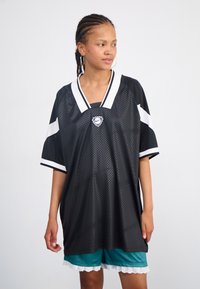 Black mesh jersey with white accents, short sleeves, and a V-neck collar. Features a logo at the chest and is paired with teal shorts with lace trim.