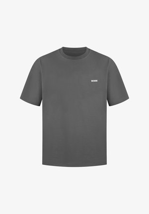 Graues Baumwoll-T-Shirt mit kurzen Ärmeln, rundem Halsausschnitt und einem kleinen weißen Etikett auf der Brust. Glatte Textur und lässige Passform.