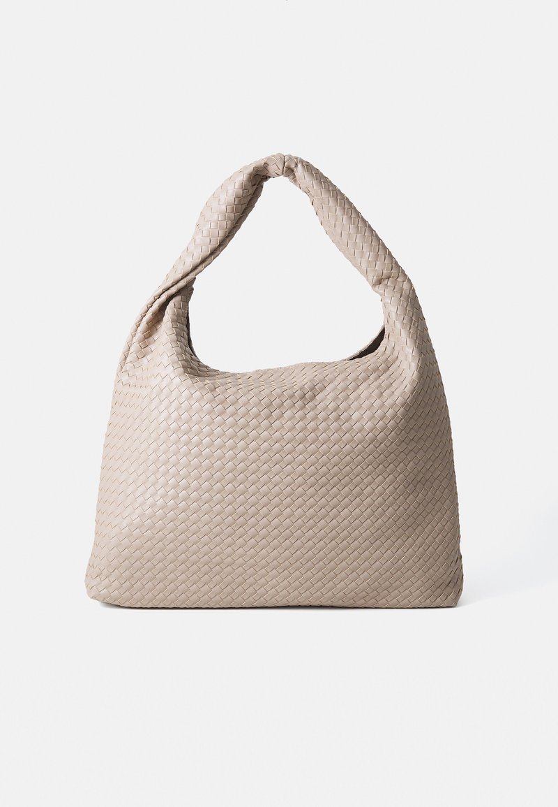 Geflochtener beige Handtasche mit einer strapazierfähigen Textur, ausgestattet mit einem einzelnen gedrehten Griff und einer lässigen, runden Form.