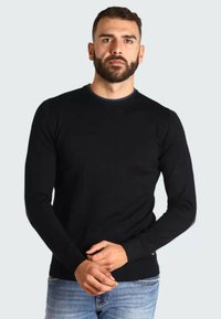 Pull noir à col ras du cou en tissu tricoté doux, avec des manches longues et un col côtelé rehaussé d'une subtile touche de bleu.