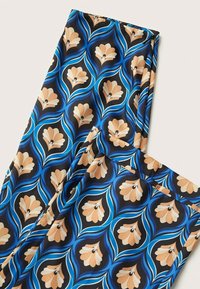 Tissu à motifs multicolores présentant des formes florales en beige et noir avec des tourbillons bleus sur un fond sombre. Texture lisse et légère.