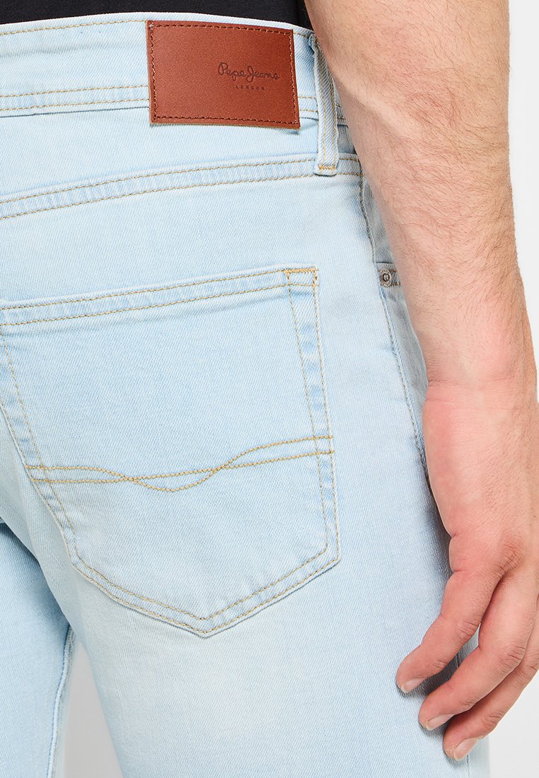 Helleblaue Denim-Jeans verfügen über ein braunes Lederpatch mit "Pepe Jeans London"-Logo, gelben Nähten und einem klassischen Fünf-Taschen-Design.