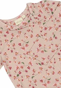 Top à manches longues floral en tissu beige doux, arborant des motifs de fleurs roses et jaunes, avec un col rond et un détail de bouton à l'épaule.