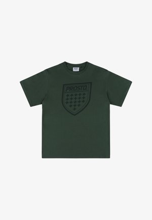 Ciemnozielona bawełniana koszulka z dużym czarnym logo w kształcie tarczy z wzorem kratki i napisem "PROSTO" na środku. Klasyczny okrągły dekolt.