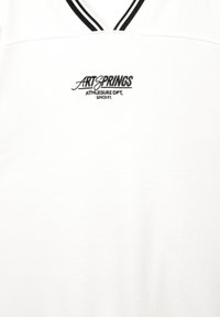 Hvid V-hals skjorte med sorte striber på kraven og sort broderet tekst "ART SPRINGS ATHLEISURE DPT. SINCE 91" på brystet.