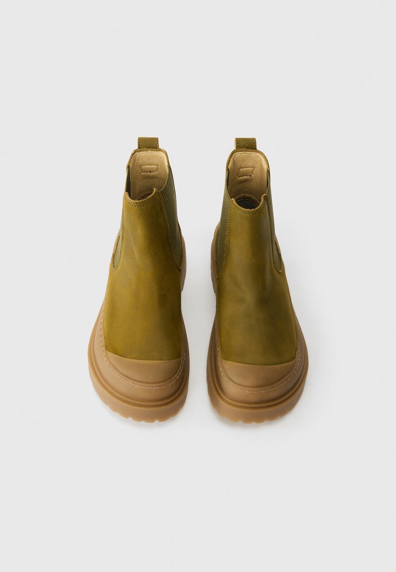 Olivgrüne Knöchelboots aus glattem Leder, mit elastischen Seitenteilen und einer beigen Gummisohle. Mit einem tonalen elastischen Zugtab.