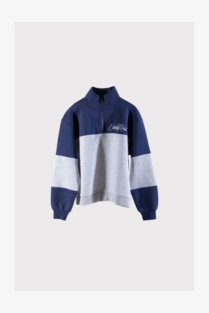 Tengerészkék és szürke színű blokkos kapucnis pulóver félcipzárral, bordás mandzsettával és laza szabással. Elülső részén hímzett szöveg található.