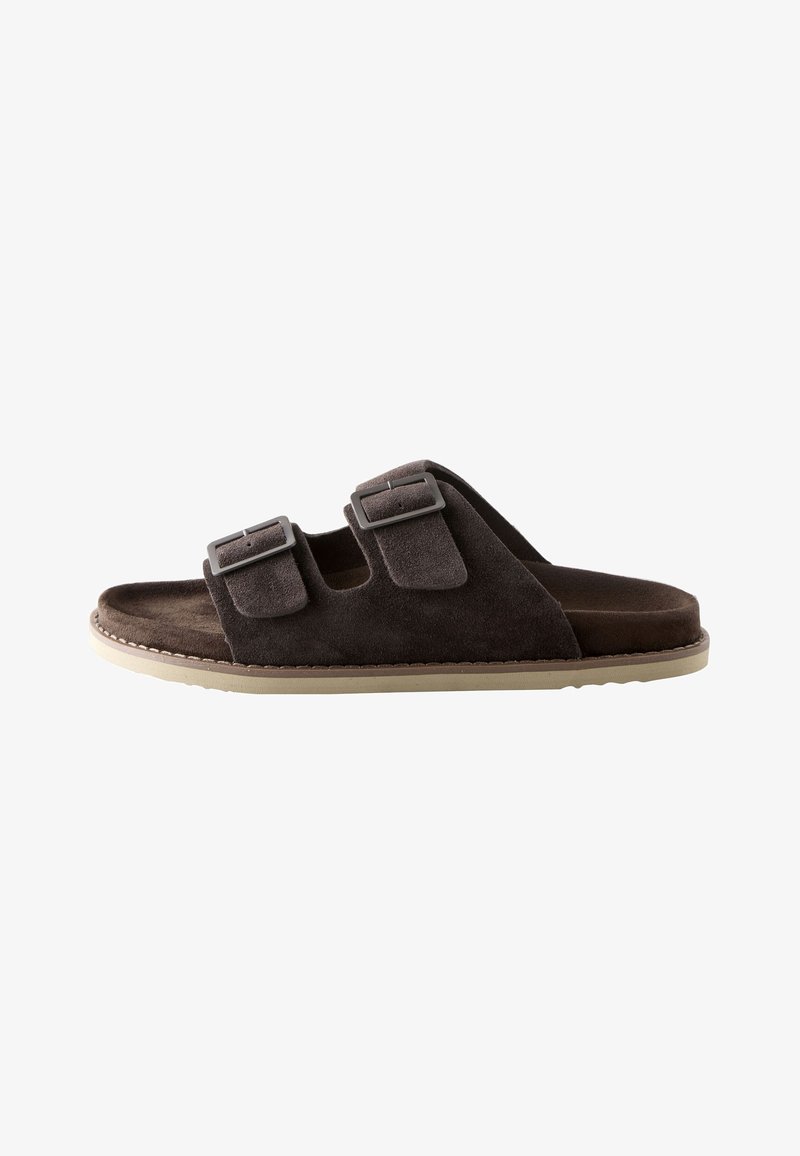Sandale slide en daim brun foncé avec deux brides à boucle ajustables et une semelle beige clair.