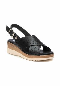 Sandalo nero con punta aperta, design perforato sulle cinghie, fibbia regolabile alla caviglia, soletta in legno e suola in gomma leggera.