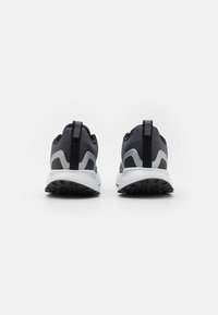 Sportlich gestaltete Schuhe mit einem dunkelgrauen Mesh-Obermaterial, hellgrauen Akzenten und einer weißen Zwischensohle. Texturierte schwarze Gummisohle. Zuglasche an der Ferse.