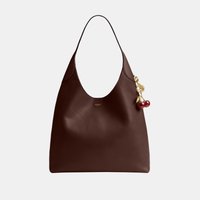 Sac à bandoulière en cuir brun foncé lisse avec un pendentif cerise doré et un logo doré subtil au centre avant.