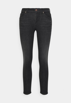 Black skinny jeans made of denim with a smooth texture, featuring a front button closure and five pockets. Legs taper down to the ankles.