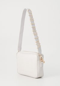 Borsa a tracolla bianca in pelle con superficie testurizzata, accessori in oro e una tracolla grigia con lettere in rilievo che formano la scritta "VALENTINO."