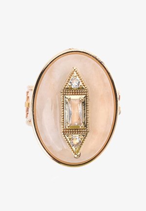 Ovale Ring mit einem glatten, hellen Stein in der Mitte, eingerahmt von filigranen goldenen Akzenten und drei kleinen, klaren Edelsteinen.