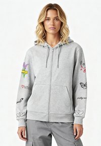 Szürke cipzáras kapucnis pulóver puha anyagból, élénk színű grafikai mintákkal az ujjakon és a mellkason, állítható kapucnival és első zsebekkel.