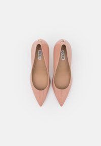 Ballerines en cuir verni rose à bout pointu, finition lisse, avec un petit accent doré près du talon et une semelle intérieure beige.