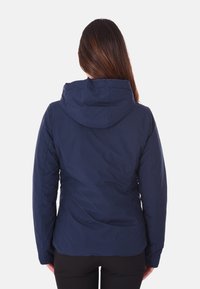 Giacca da donna con cappuccio di colore blu navy, realizzata in un tessuto morbido e testurizzato, dalla forma aderente e con vita leggermente arricciata per un look sartoriale.