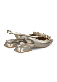Chaussures slingback en métal doré avec un talon carré, ornées de détails décoratifs sur le dessus et d'une texture lisse sur l'ensemble.