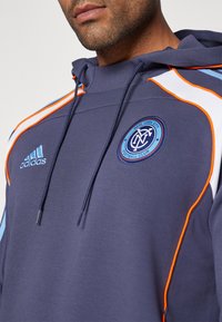 Felpa con cappuccio blu navy, con dettagli arancioni e azzurri chiari, dotata di cappuccio con lacci e logo ricamato del New York City Football Club.