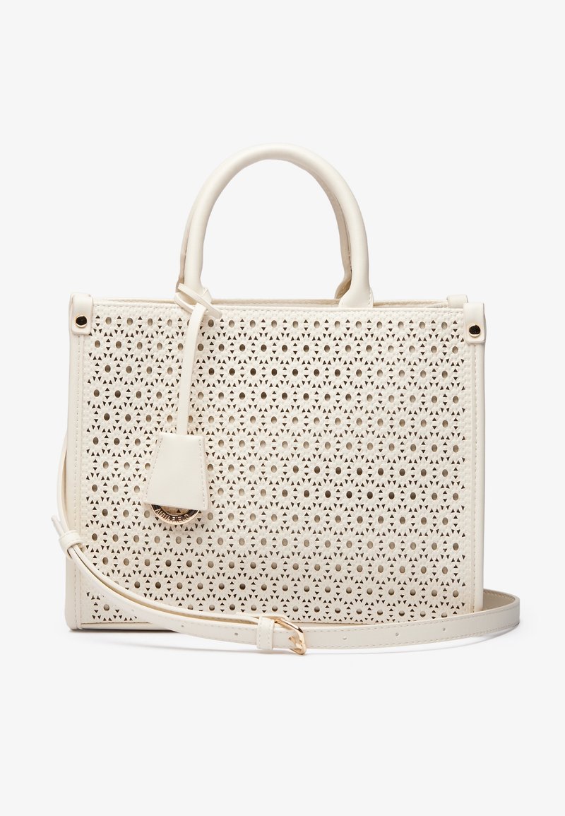 Sac à main blanc perforé avec doubles poignées, bandoulière amovible, accents en métal doré, forme rectangulaire structurée, intérieur lisse.