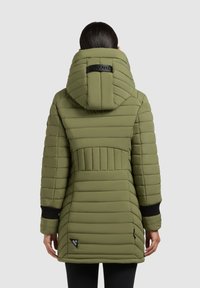Giacca parka imbottita di colore verde oliva, con un colletto alto, cuciture orizzontali e polsini a coste neri. Include un'etichetta con il logo sull'orlo.