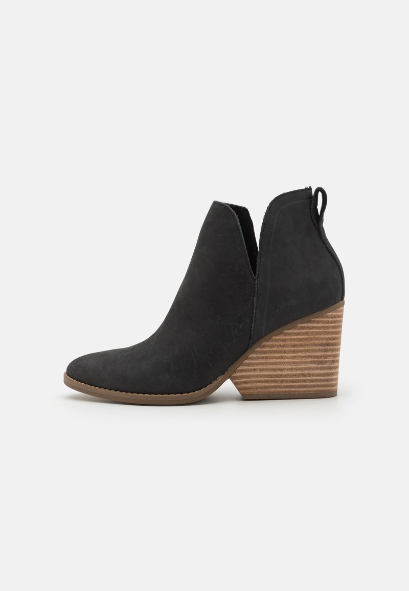 Schwarze Wildleder-Stiefeletten mit spitzem Zehenbereich und einem hohlen Ausschnitt-Design. Sie verfügen über einen gestapelten Holzabsatz und eine Schlaufe zum einfachen Anziehen.
