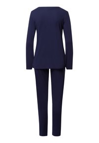 Sada loungewear v námořnicky modré barvě, zahrnující dlouhý rukáv s širokým výstřihem a odpovídající zúžené kalhoty, vyrobené z měkké a lehké tkaniny.