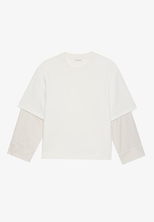 Camisa blanca de manga corta con inserto de manga larga en gris claro, con textura acanalada. Diseño sencillo, cuello redondo, tejido suave y corte casual.