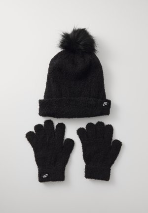 Cappello di lana nera con pompon in pelliccia sintetica e guanti, entrambi caratterizzati da una texture morbida e un piccolo etichetta con il marchio sul polsino.