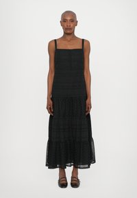 Rochie maxi neagră, cu bretele subțiri, decolteu pătrat, material texturat, tiv cu volane stratificate și închidere cu nasturi pe partea din față.