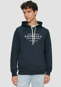 Felpa con cappuccio blu navy con laccetti bianchi e testo stampato sul davanti. Polsini e orlo a costine. Tessuto morbido con una vestibilità comoda.