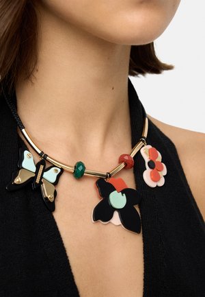 Kolorowy naszyjnik z wisiorkami w kształcie kwiatów i motyli w kolorach czarnym, czerwonym i zielonym, elementy w złotym odcieniu oraz teksturowane koraliki, na czarnym topie.