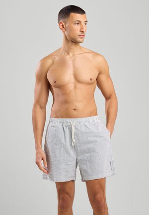 Shorts de bain pour hommes en bleu clair et rayures blanches, avec une taille élastique et un cordon de serrage, dotés de poches latérales et d'une coupe décontractée.