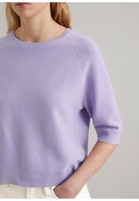 Lila dziergana sweter z okrągłym dekoltem, krótkimi rękawami raglanowymi i luźnym fasonem, z teksturowanym wzorem ściegów.