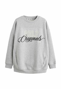 Felpa grigia con scollatura a girocollo, spalle scese e tasche laterali. Presenta la scritta "SELF Originals 2023" in colori a contrasto.