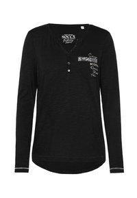 Zwarte lange mouwen top met een henley halslijn, voorzien van een voorzak met sequin detail en witte tekstaccenten. Zachte, gestructureerde stof.