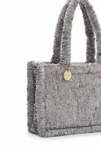 Borsa tote grigia con texture, in tessuto morbido, dotata di due manici ad anello e di un'etichetta con logo dorata attaccata da una catena. Presenta una forma rettangolare e dettagli cuciti.