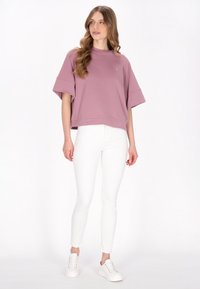 Felpa a maniche corte, rosa polveroso, dalla vestibilità comoda con scollo rotondo, abbinata a pantaloni bianchi attillati e scarpe da ginnastica bianche. Design semplice, texture morbida.