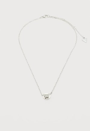 Collier délicat en chaîne argentée avec un petit pendentif rond orné d'un motif gravé de chouette et un fermoir ajustable avec un charme triangulaire.
